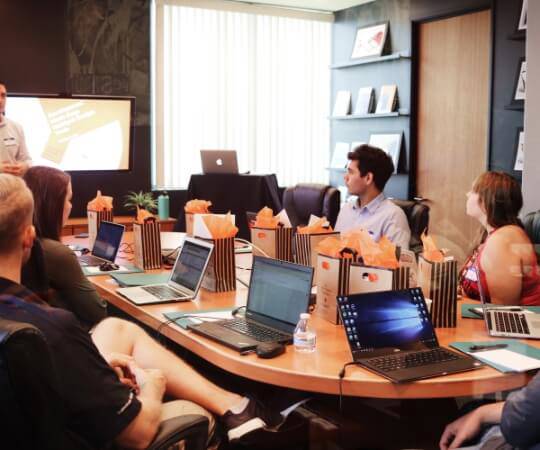 staff members in meeting room on laptops